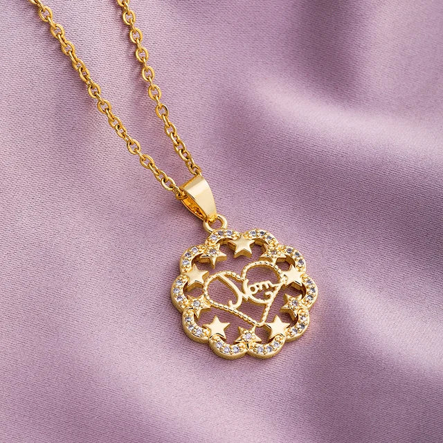 a gold necklace with a heart and stars on it