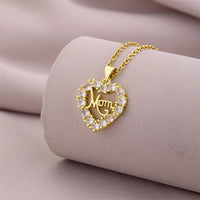 a gold necklace with a heart and a mom on it