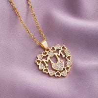 a gold necklace with a heart and two hearts on it