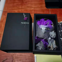 a black box with a purple tie and a black box with a purple bow