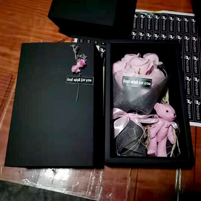 a box with a bouquet of pink roses in it