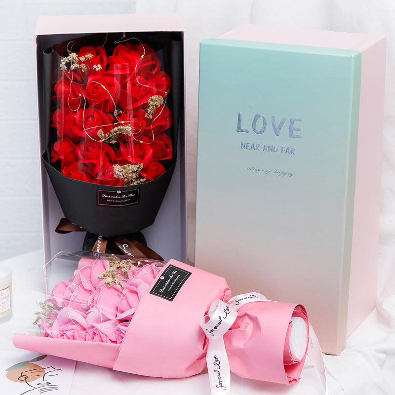 a box with a bouquet of red roses inside of it