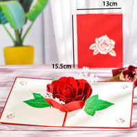 a card with a red rose on top of it