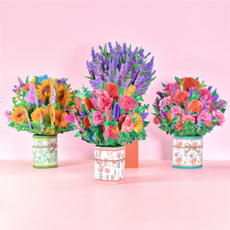 three tin cans filled with colorful flowers on a table