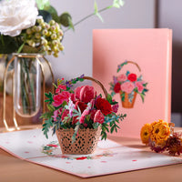 a basket of flowers sitting on a table next to a card