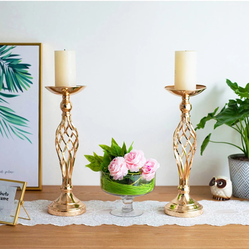 a table topped with two candles and a vase filled with flowers