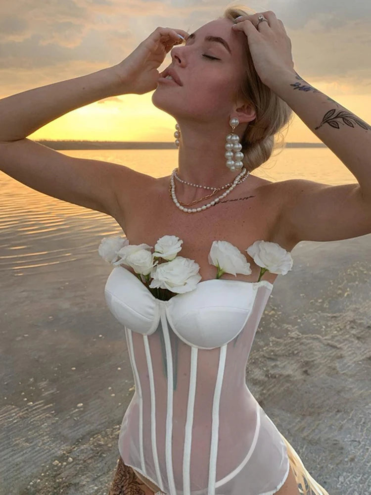 a woman in a white corset on the beach