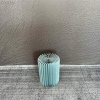a blue vase sitting on top of a floor next to a wall