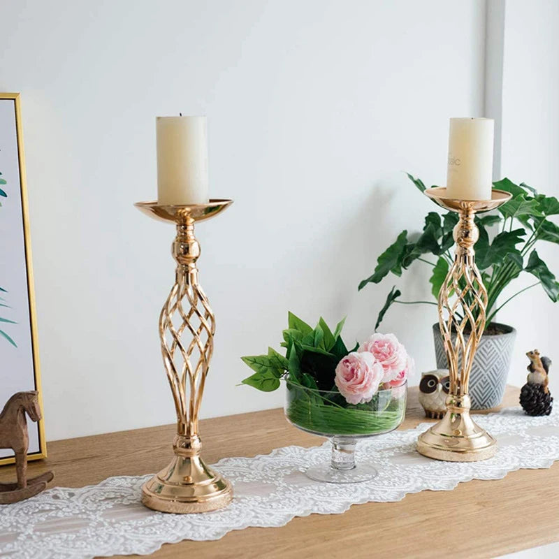 a table topped with two candles and a vase filled with flowers