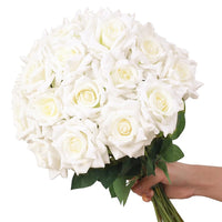 a hand holding a bouquet of white roses