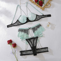 Pastel blue and black ethical lace underwear set with chic garters, adjustable straps, and elegant lace design.