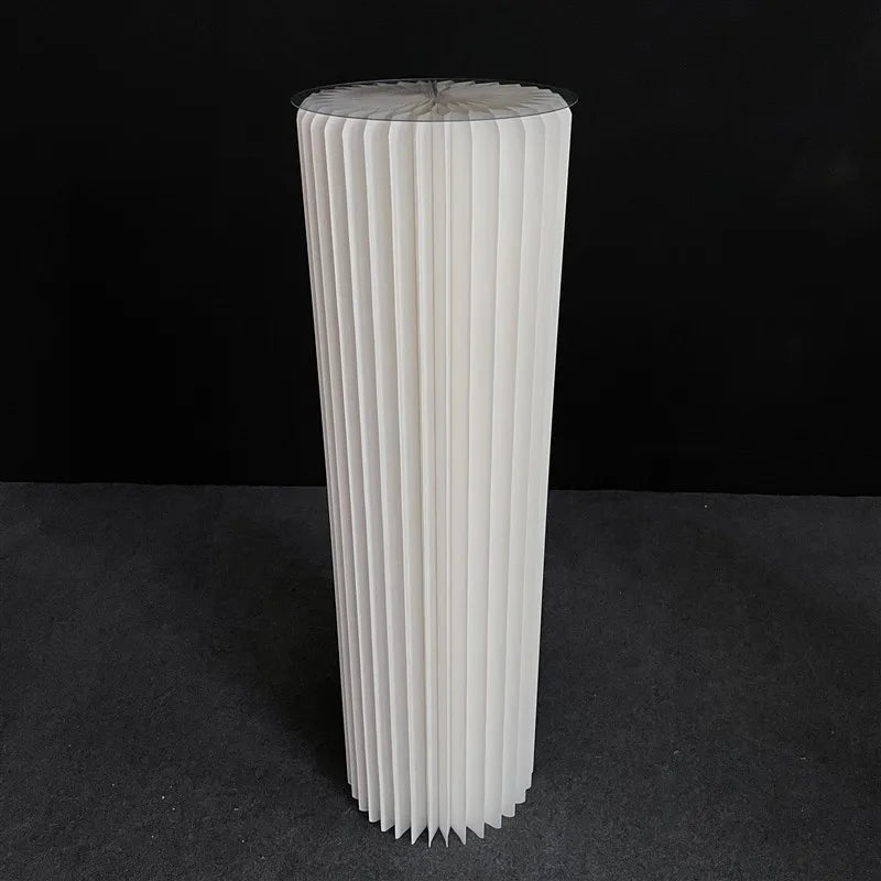 a tall white vase sitting on top of a table