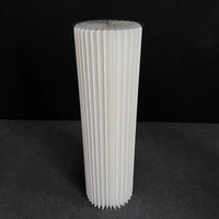 a tall white vase sitting on top of a table