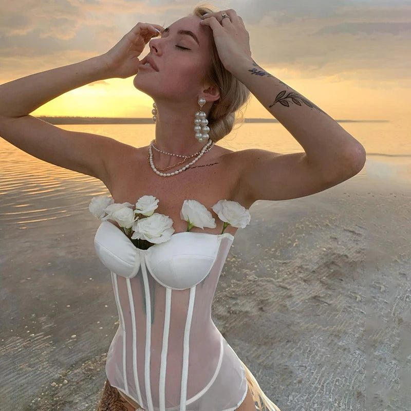 a woman in a white corset on the beach