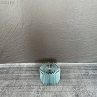 a blue vase sitting on top of a floor next to a wall