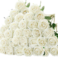 a bouquet of white roses with green leaves