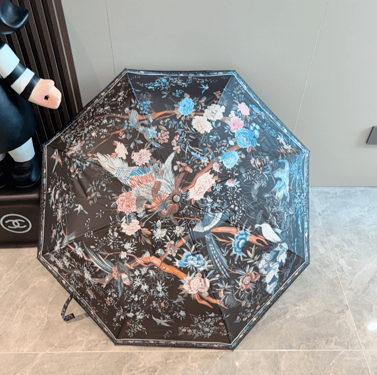 Elegant printed black umbrella adorned with floral and bird designs, perfect for luxurious weddings and stylish outdoor events.