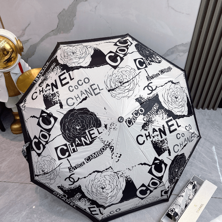 Stylish umbrella featuring elegant Chanel print on a chic black and white design, perfect for rainy or sunny days.