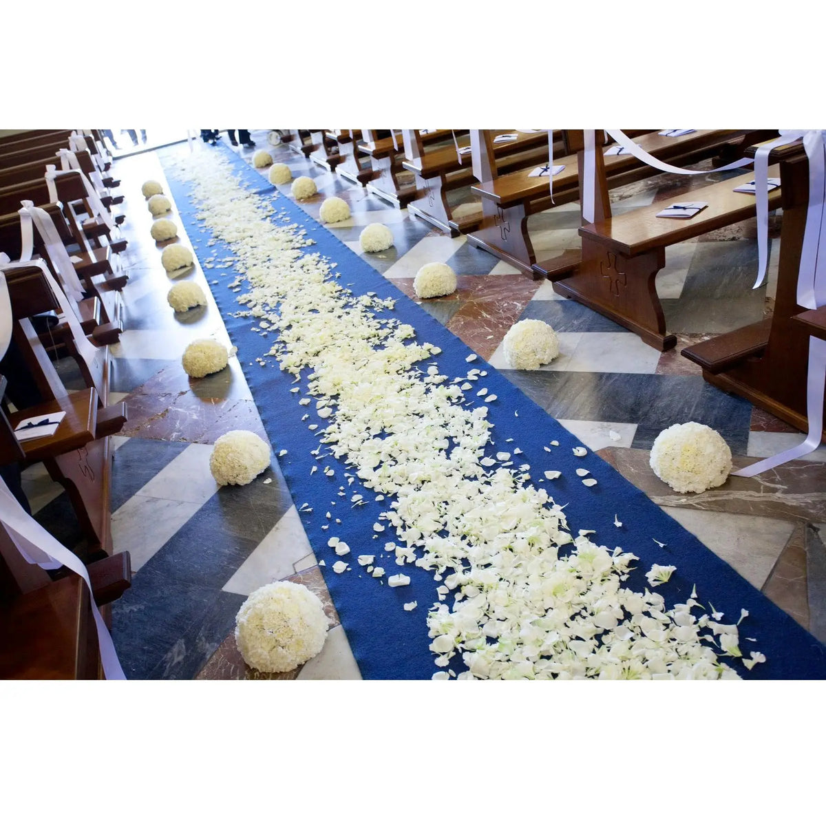 a row of pews filled with lots of white flowers