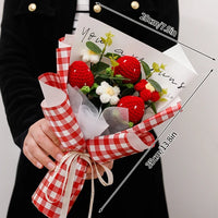 a person holding a bouquet of strawberries and flowers