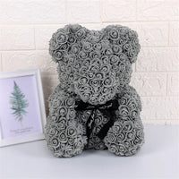 a gray teddy bear sitting next to a picture frame