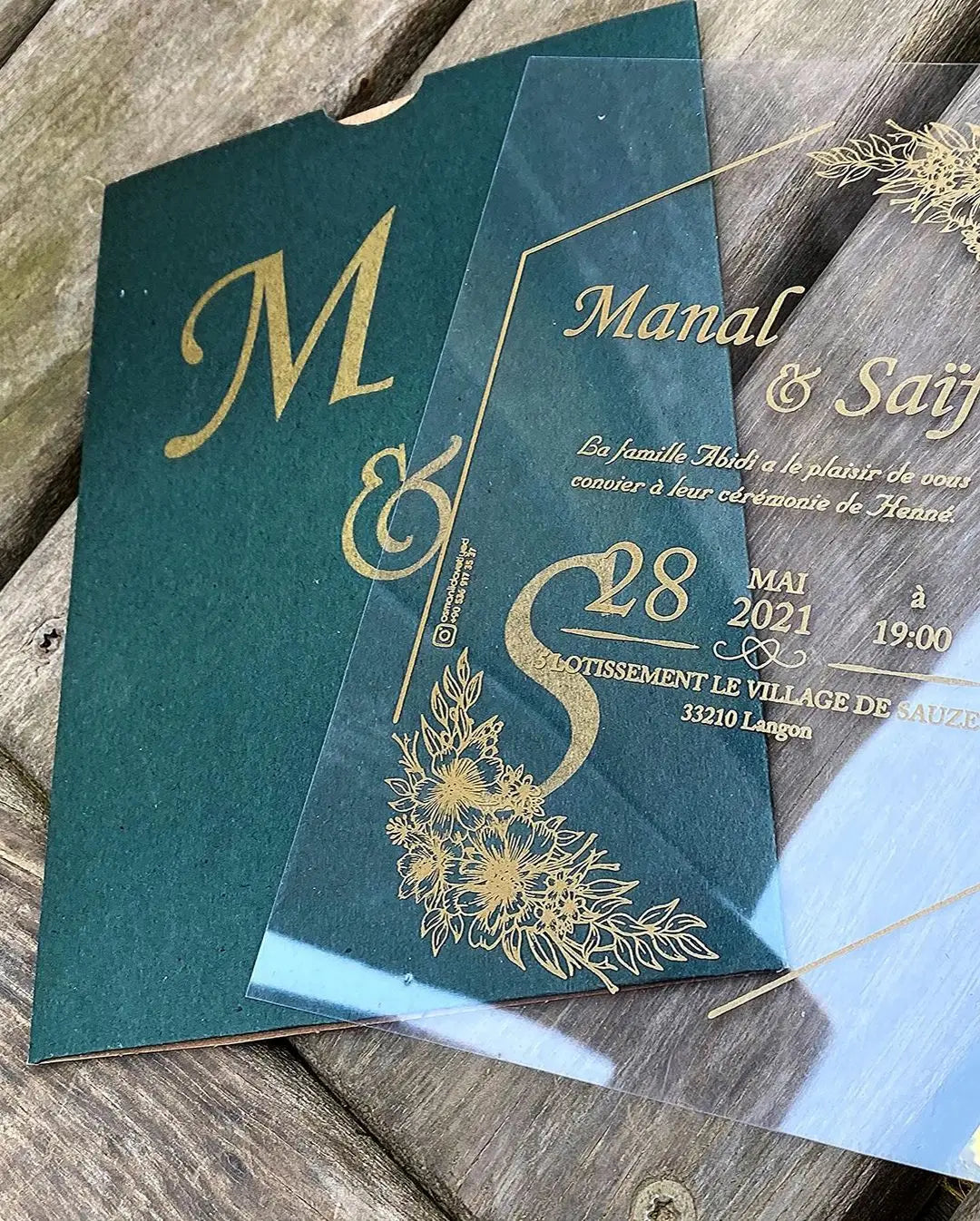 a close up of two wedding cards on a wooden table