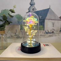 a fake flower under a glass dome on a table