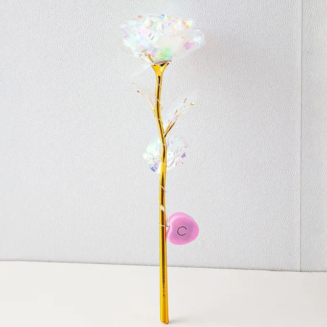 a gold vase with a white flower on a table