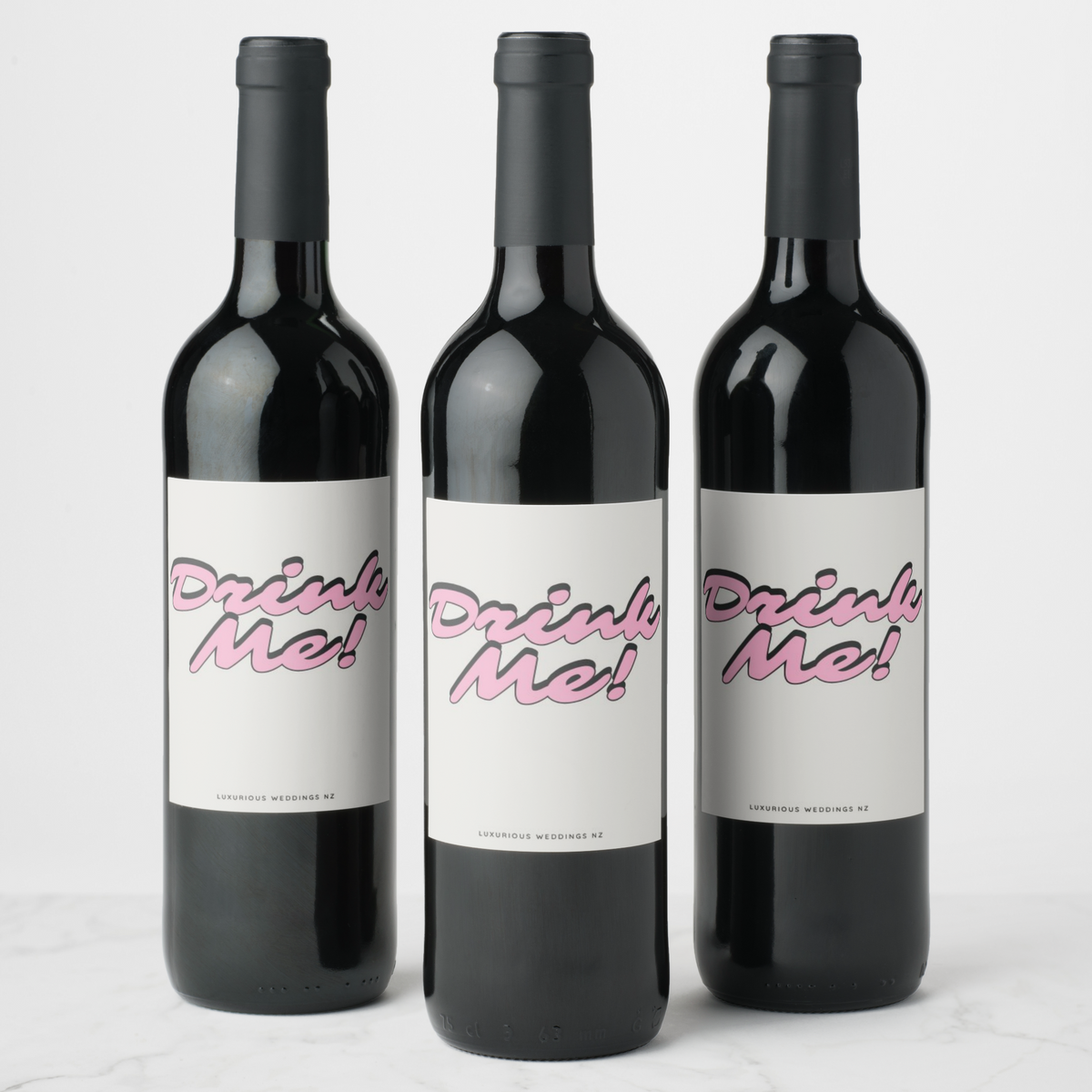 Bachelorette wine bottles with playful 'Drink Me!' labels by Luxurious Weddings, perfect for celebrations.