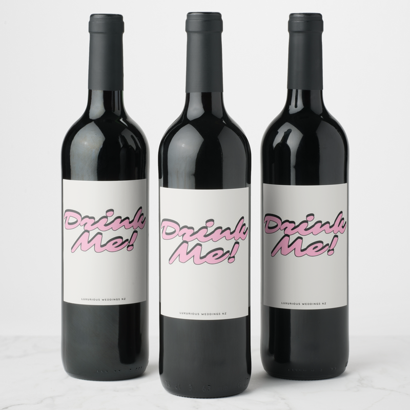 Bachelorette wine bottles with playful 'Drink Me!' labels by Luxurious Weddings, perfect for celebrations.