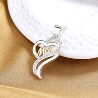 a heart shaped pendant with the word mom on it