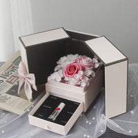 a white box with a pink rose inside of it