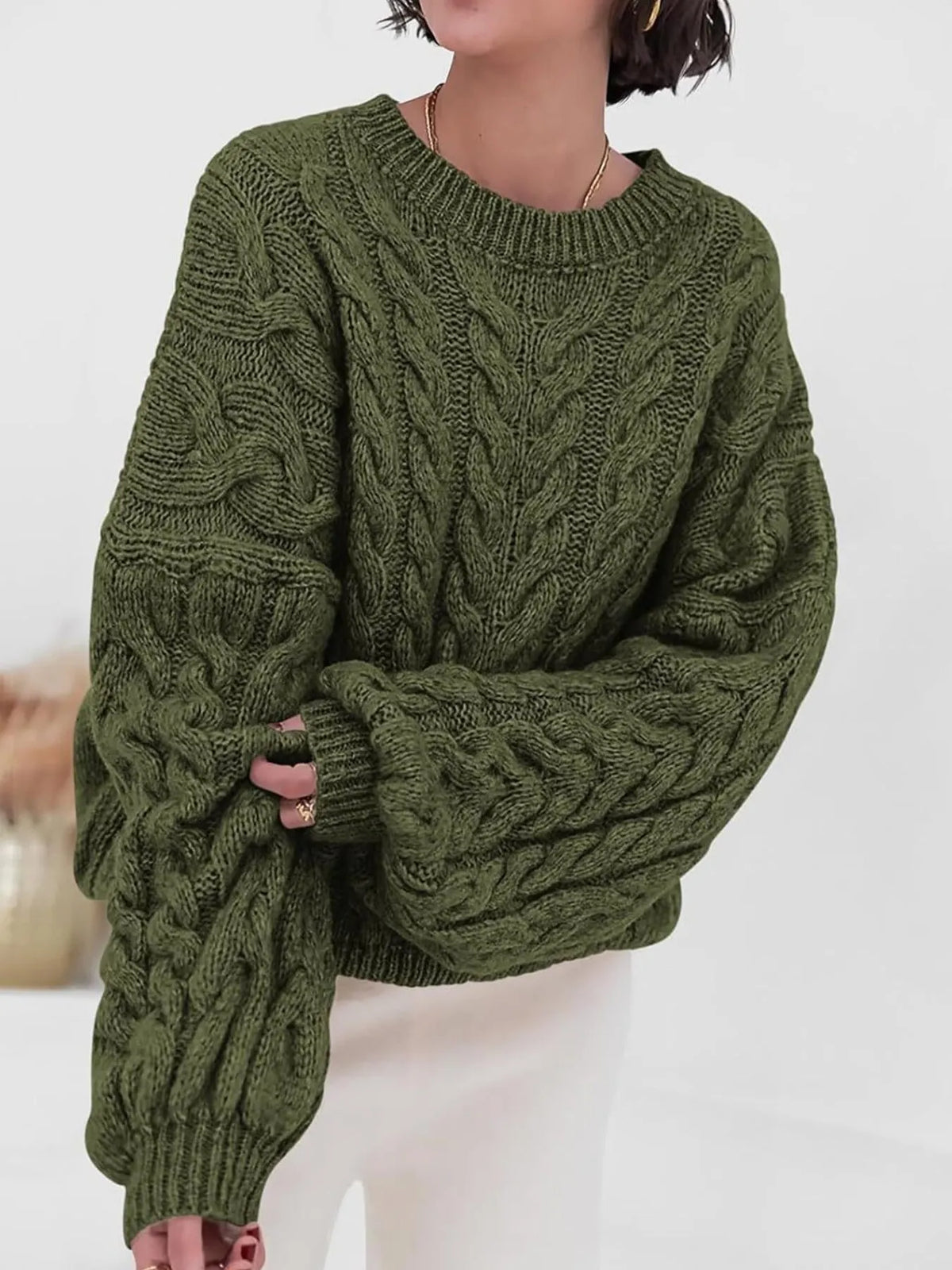 Cozy cable knit long sleeve sweater in olive green, featuring a relaxed fit and chunky knit texture.