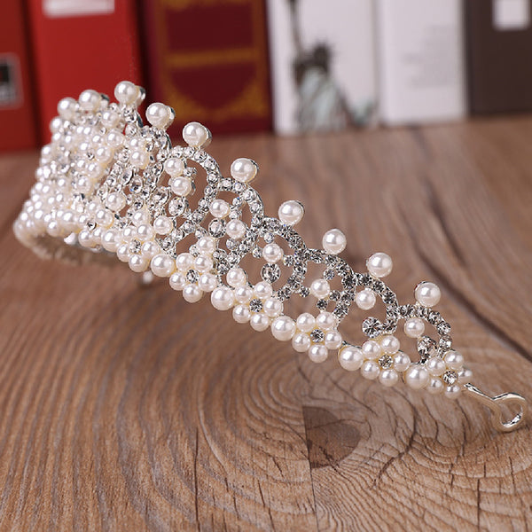 a tiara made of pearls on a wooden table