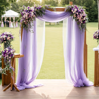 a purple and white wedding arch decorated with flowers
