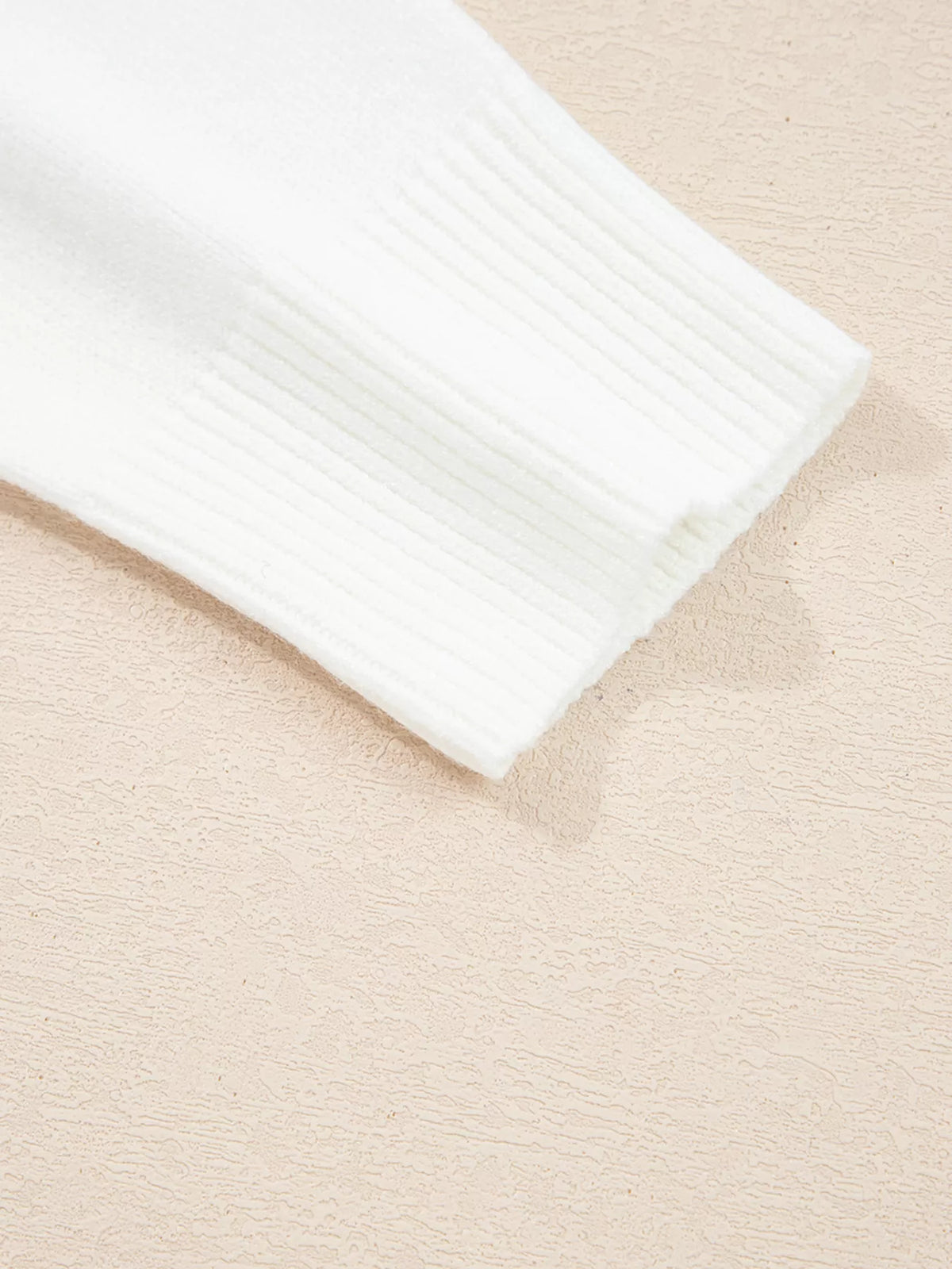 Detail of sleeve cuff of MERRY Letter Pattern Christmas Raglan Sleeve Sweater in white color.