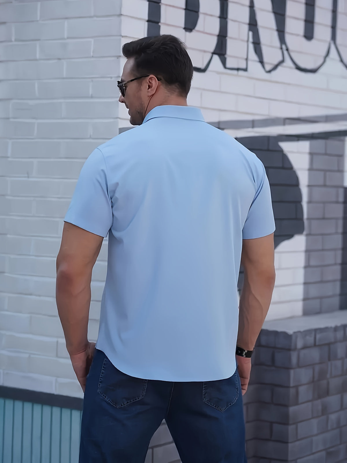 a man standing in front of a brick building