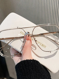 Hand holding oversized sunglasses with a stylish case, ideal for luxurious weddings and formal wear in NZ.