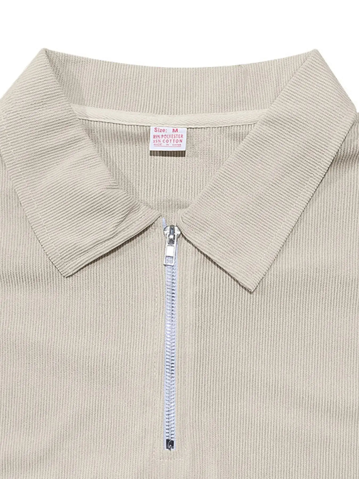 Close-up of men's quarter zip polo collar in beige, featuring a sleek design and textured fabric.