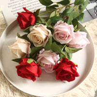 a white plate topped with lots of pink and red roses