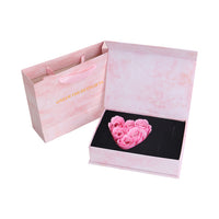 a pink gift bag with pink roses in it