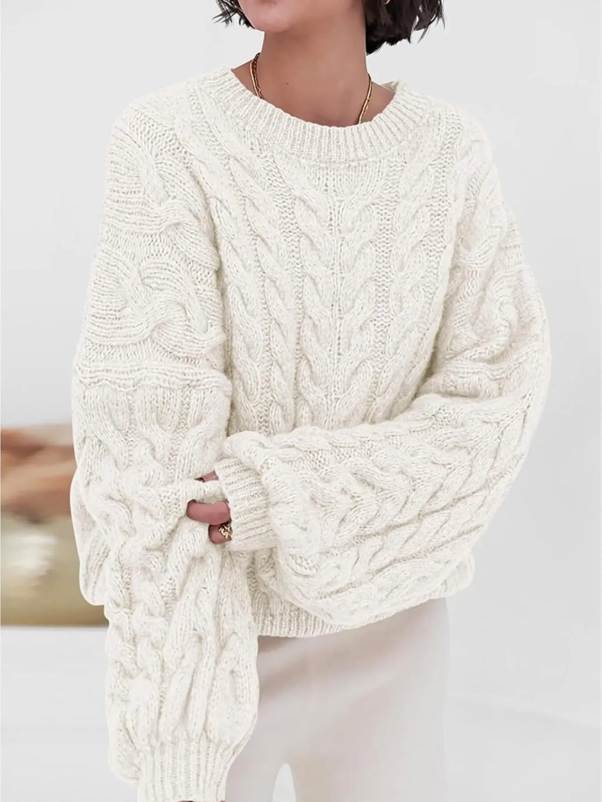 Cozy cable knit long sleeve sweater in cream, showcasing a relaxed fit and textured design, perfect for cold weather.