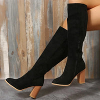 Black point toe block heel boots with high shaft and rubber sole, showcasing stylish design and comfort.