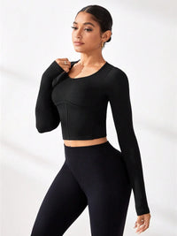 Model wearing a round neck long sleeve active T-shirt paired with ribbed leggings in black.