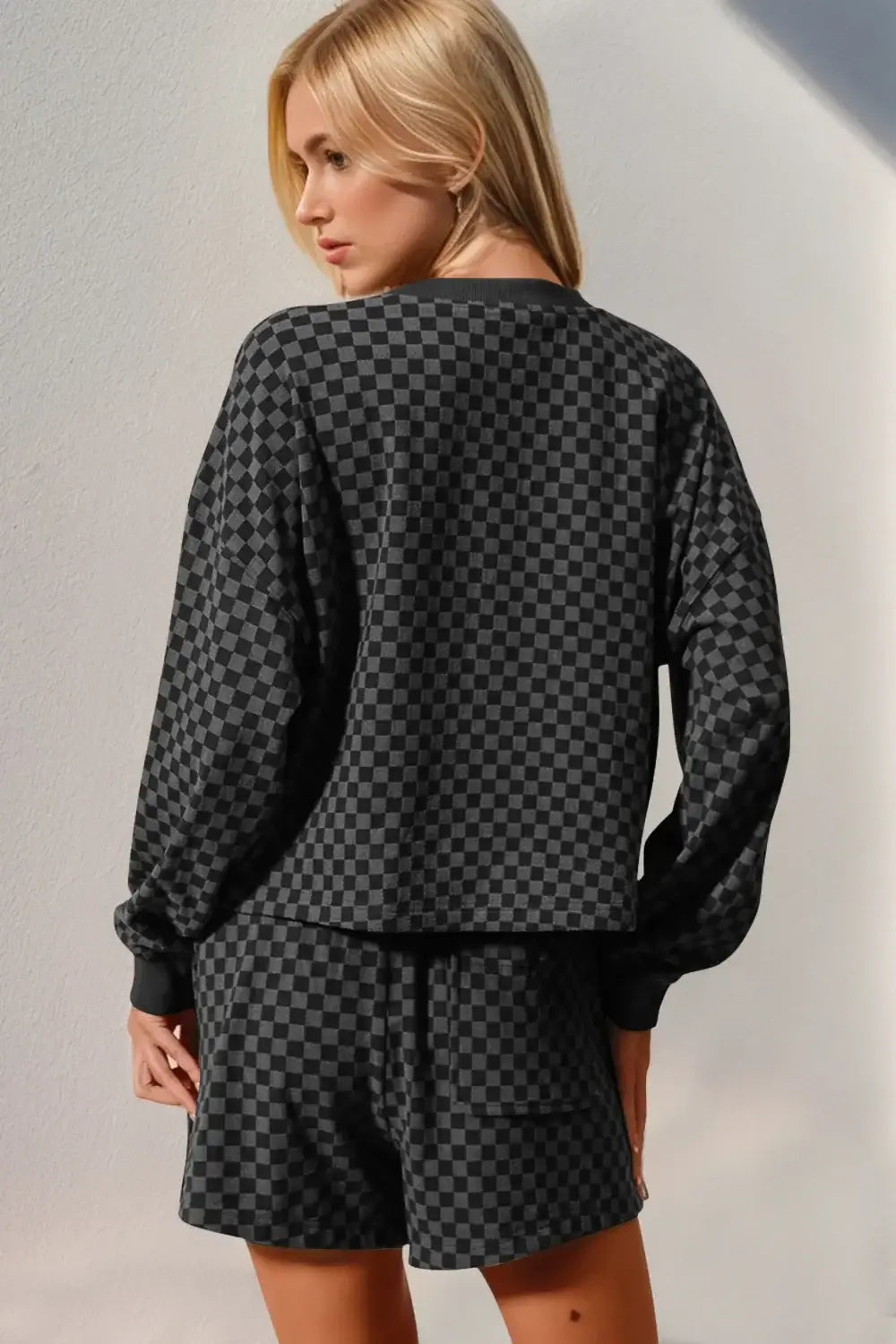 Back view of woman wearing a checkered half button top and shorts set, showcasing the stylish, slightly stretchy fabric.