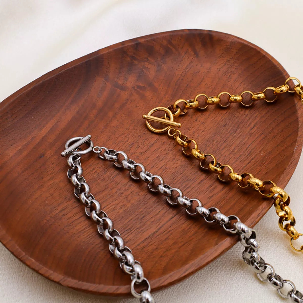 Heart Pendant Toggle Clasp Chain Necklace displayed on a wooden plate, featuring silver and gold links.
