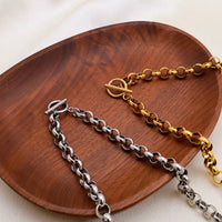 Heart Pendant Toggle Clasp Chain Necklace displayed on a wooden plate, featuring silver and gold links.
