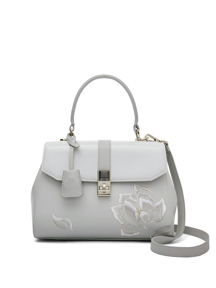 a white purse with a flower design on it