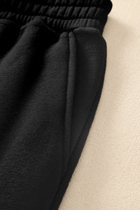 Close-up of pocketed black joggers showcasing elastic waistband and soft fabric for affordable activewear.