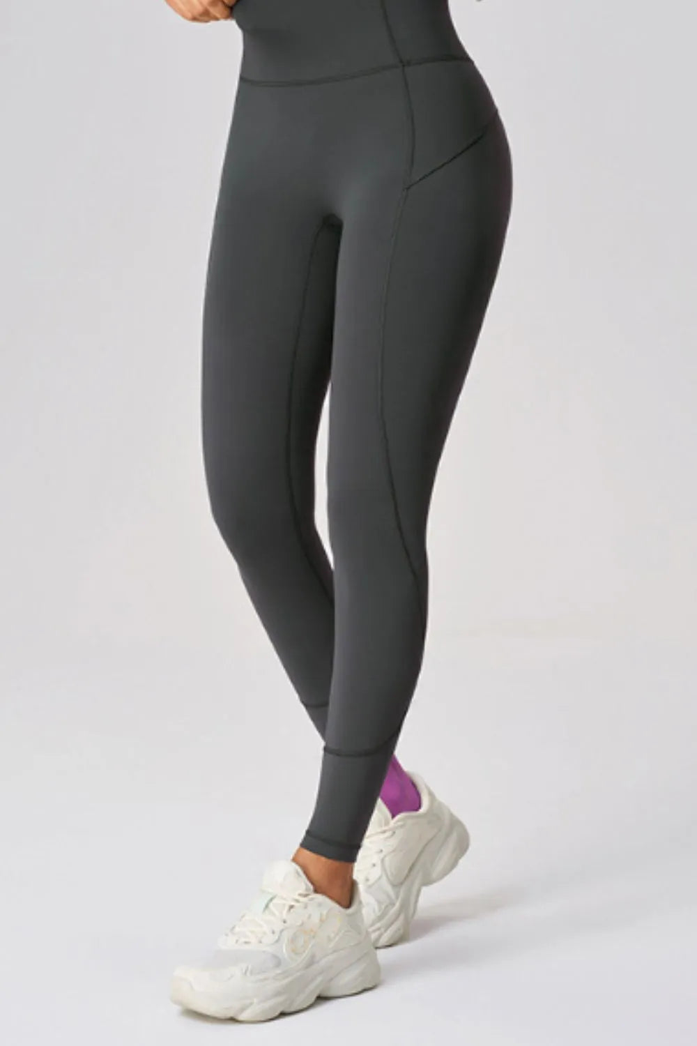 High waist active leggings in dark gray with pocket, worn with white sneakers, showcasing stretch and fit.